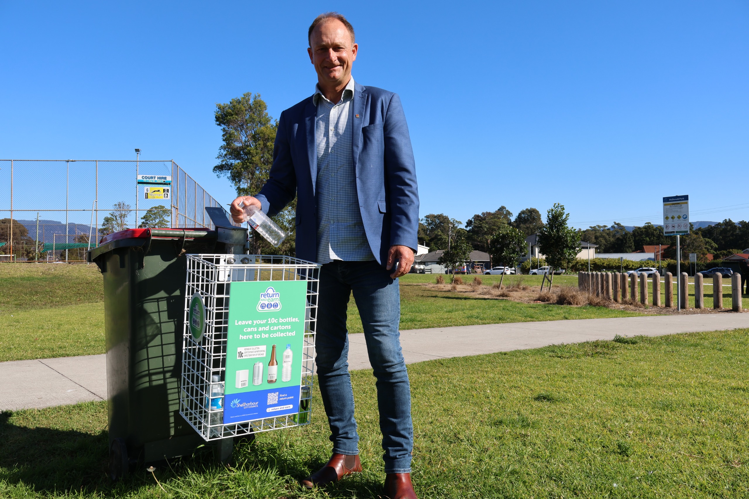Mayor Chris Homer using the new Return & Earn basket at McDonald Park, Albion Park